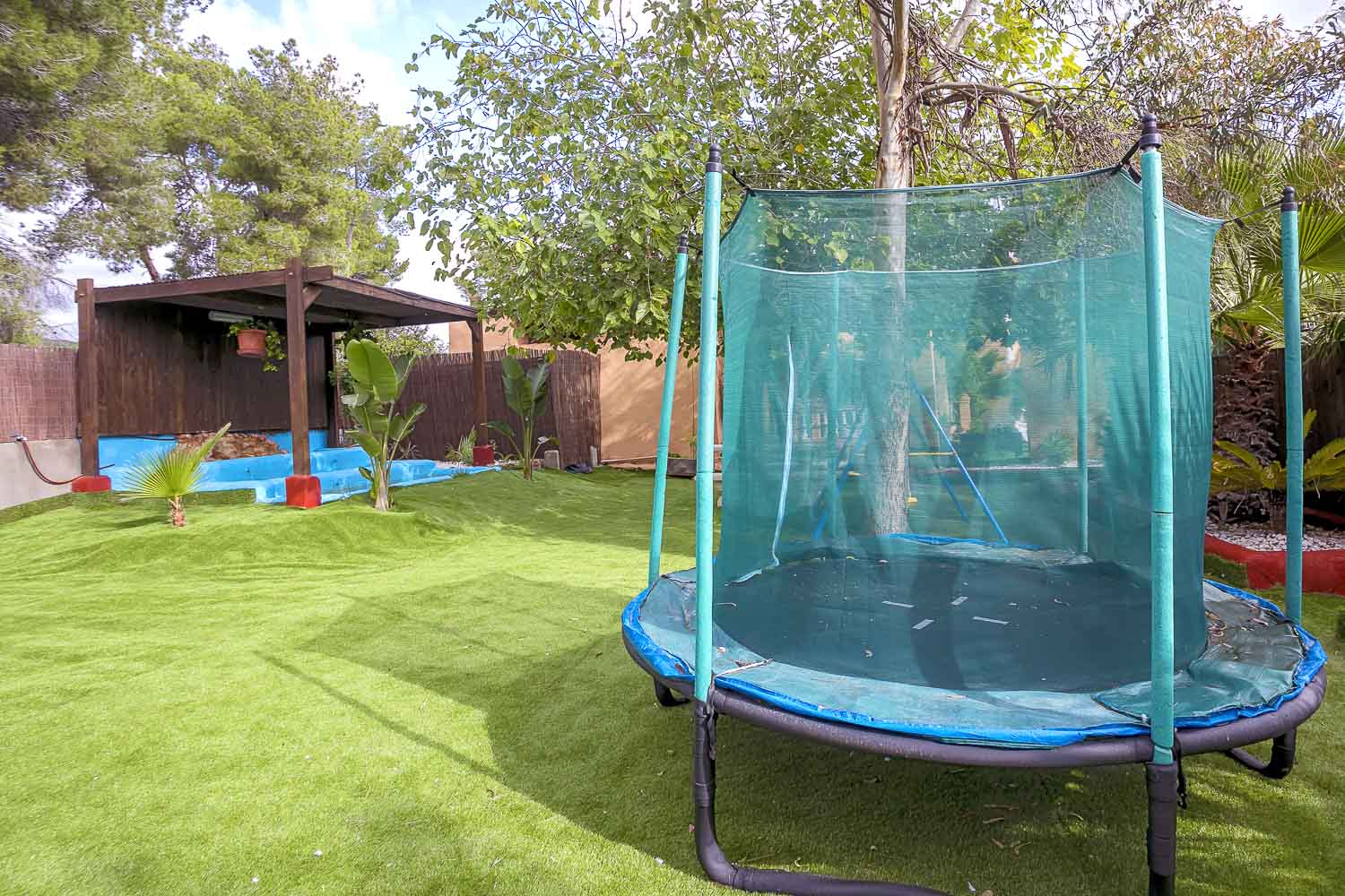 Jardn con cama elstica en una villa en Ibiza